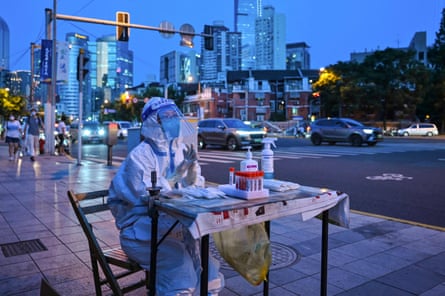 A health worker waits to test people for the Covid-19 coronavirus on a street next to a residential area in the Jing’an district of Shanghai on July 5, 2022.