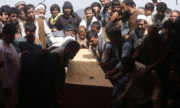 Afghans carry the body of a victim of the Dubai City wedding hall bombing during a mass funeral.