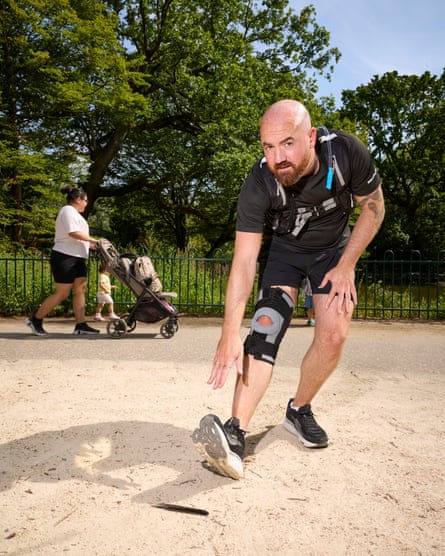 Ioan stretches in the park, reaching out towards his outstretched foot