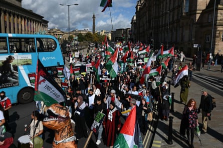 Palestine campaigners gather with flags for a march