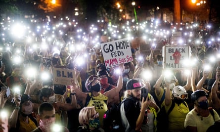 In this July 20, 2020, file photo, hundreds of Black Lives Matter protesters hold their phones aloft in Portland, Oregon.