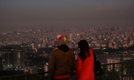 People looking out over Tehran after explosions were heard