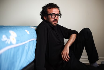a man sits on the floor in front of a mattress