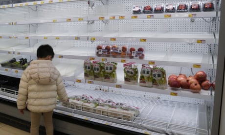A boy looks at empty shelves in a supermarket in Hong Kong