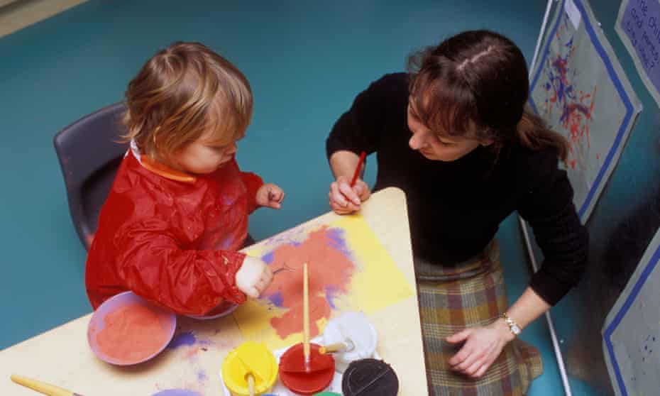 Teacher and child in nursery UK