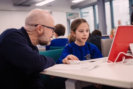Adult next to girl at computer screen