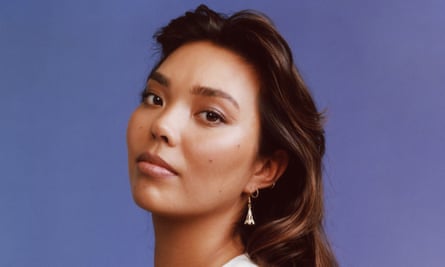 A model poses with her head back and looks at the camera. She’s wearing Eiffel Tower earrings
