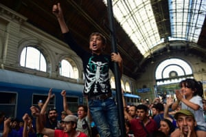 A young protester climbs a pole at the station