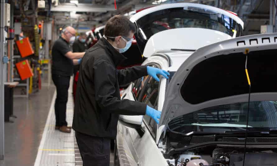 Members of staff working between two-metre wide designated work stations on a car assembly line at the Vauxhall car factory during preparedness tests and redesign ahead of re-opening.