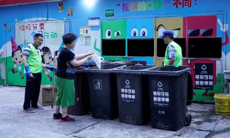 A woman throws at a waste sorting site in Shanghai. Residents face penalties for using the wrong bins.