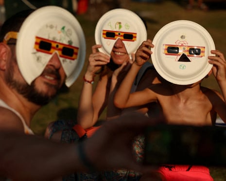 Angela, David and their son, Diego, 7, pose for a selfie with protective eclipse glasses during the watch party for the solar eclipse, in Buitrago del Lozoya, Spain.