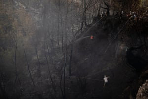 People try to put out wildfires in the village of Yuvarlak Cay