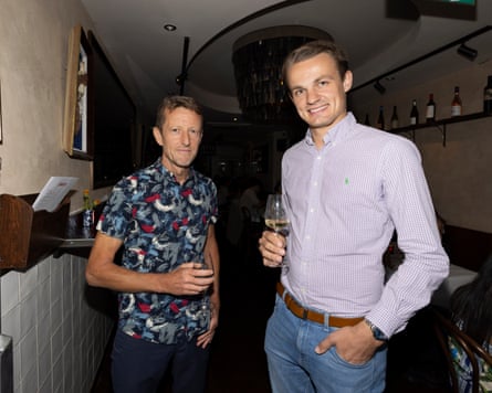 Tim and Lewis standing inside with drinks