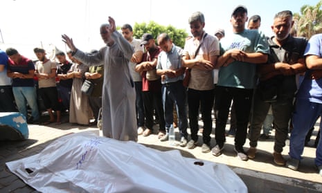 Relatives of a Palestinian killed in Israeli attacks mourn before his burial in Dair El-Balah, central Gaza, on Friday