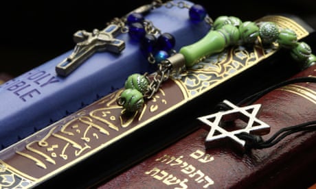 A Bible, a Qu’ran and and a Torah displayed with Interfaith symbols.