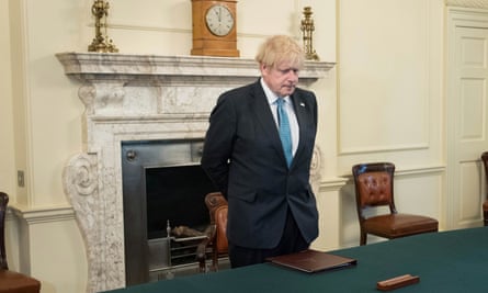 Boris Johnson observes the minute’s silence at 10 Downing Street in London.