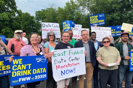 people hold signs against a data center