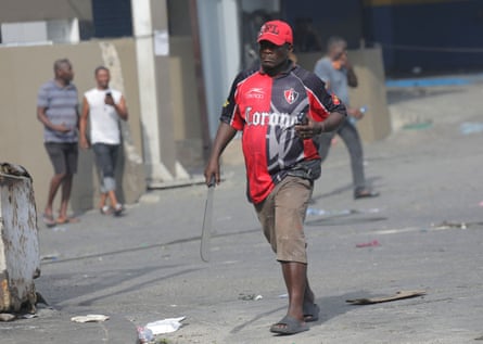 A neighbourhood leader holds a machete during protests over rising fuel prices and crime in Port-au-Prince this week.