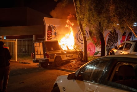 A police vehicle burns outside the Alice Springs hospital where Jefferson Lewis was being treated.