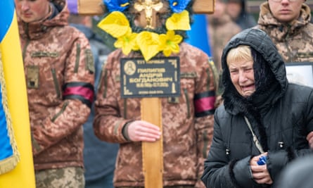A mother weeps near her son’s grave during a burial ceremony at the Lychakiv cemetery in Lviv.