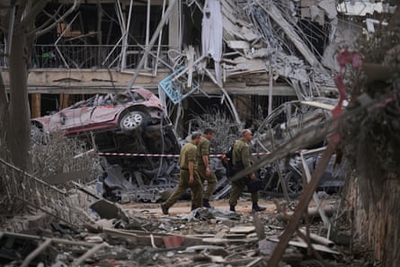 Israeli security forces inspect destroyed residential buildings that were hit by a missile fired from Iran