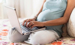 Pregnant mother using laptop computer in bed