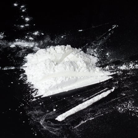 Pile of cocaine with line on black table.
