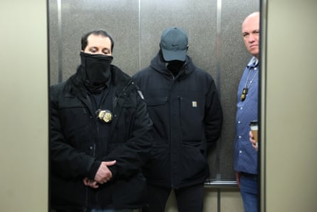 Masked agents stand watch in a hallway