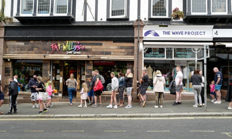 Holiday-makers queuing outside a surf clothing shop in Newquay, Cornwall, last week.