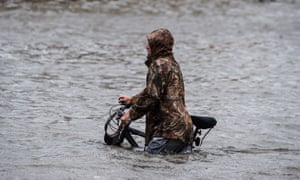 A man walks his bicycle through a street flooded by Hurricane Sally in Pensacola, Florida.