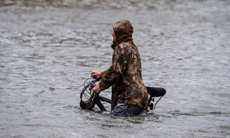 A man walks his bicycle through a street flooded by Hurricane Sally in Pensacola, Florida, in September 2020. 