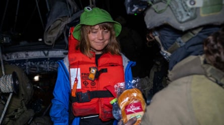 An Israeli soldier passes food to Thunberg