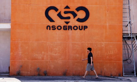 A man walks past the logo of NSO Group at one of its locations in southern Israel