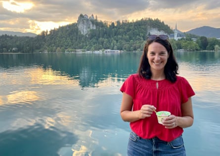 Hannah Stanton in a red shirt in front of a lake and a castle