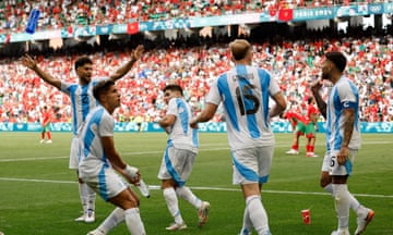 Julián Álvarez ducks as a bottle (top left) is thrown at celebrating Argentina players by angry spectators during their match with Morocco in Saint-Étienne, forcing the Group A encounter to be suspended