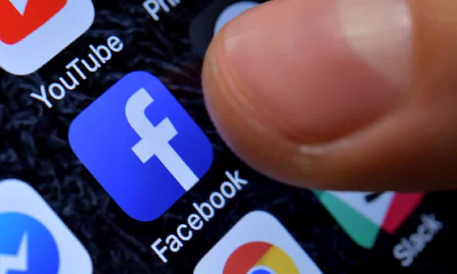 Thumb over Facebook app on phone screen