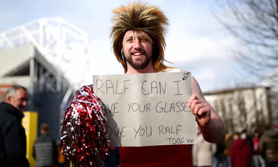 A Manchester United fan outside Old Trafford holds a sign prior to the Premier League match between against Watford in February 2022.