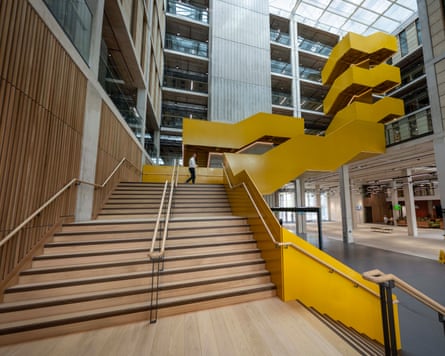 A sweeping yellow multistorey staircase inside the atrium of the Sloane Robinson building