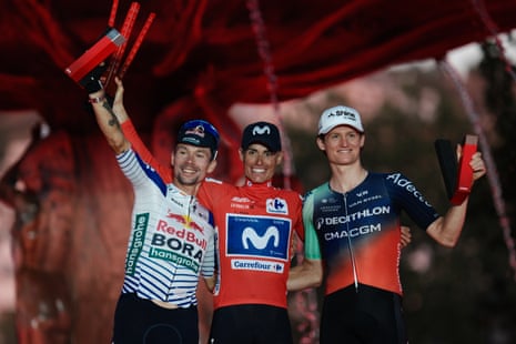 Enric Mas (centre) smiles on the podium flanked by second-place Slovenia's Primoz Roglic (left), and third-place Felix Gall.