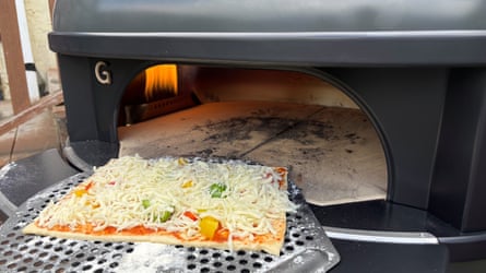 A pizza being fed into the Gozney Dome Gen 2 pizza oven.