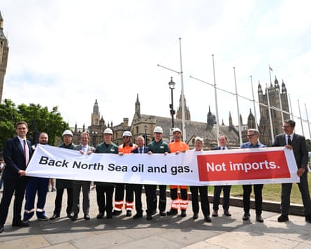 A group of workers in suits and hard hats hold a banner reading 'Back North Sea oil and gas. Not imports.' in Parliament Square
