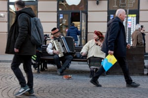 Musicians perform while people make their way through a street as the city continues to prepare for the possibility of a Russian military attack in Lviv