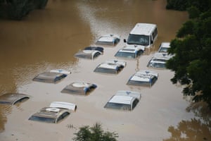 Rows of vehicles mostly submerged in flood water