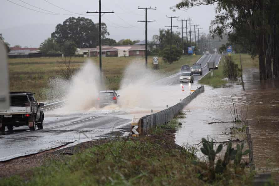 A driver chances their hand on a flooded section of Plainland-Laidley road.