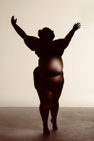 A a fat-celebrating dancer stand with arms aloft