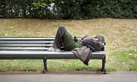 A homeless man sleeping on a bench in central London.