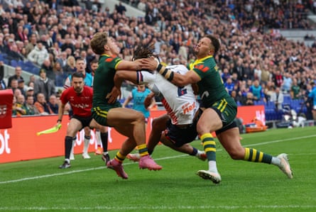 England’s Dom Young is tackled by Australia’s Reece Walsh and Gehamat Shibasaki.