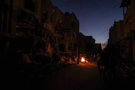 People gather round a fire in the streets of Khan Younis.