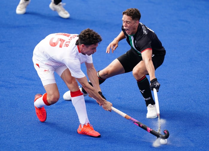 Phillip Roper and Wales' Dale Hutchinson battle for the ball in the men's hockey.
