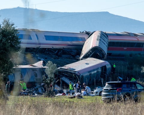 Overturned, mangled train carriages lie in a field after a collision near Urda, Spain
